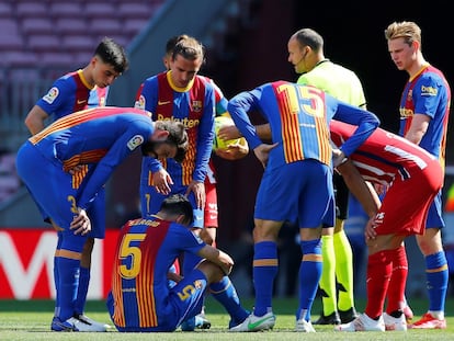 El árbitro Mateu Lahoz y varios jugadores se interesan por el estado del jugador del FC Barcelona Sergio Busquets, conmocionado tras un golpe.