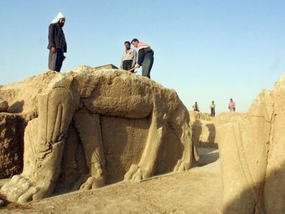 Treballadors netegen una estàtua en un jaciment arqueològic a Nimrud.