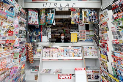 Un vendedor con una mascara en un kiosko de prensa en Budapest, este lunes. 