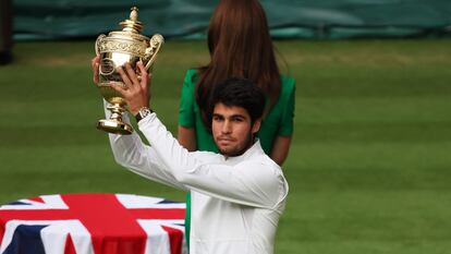 Carlos Alcaraz levanta el trofeo tras ganar la final de Wimbledon, en Londres, este domingo.