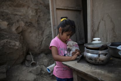 Una niña mira videos en un smartphone en el barrio de Nueva Esperanza, en Lima, en 2020.