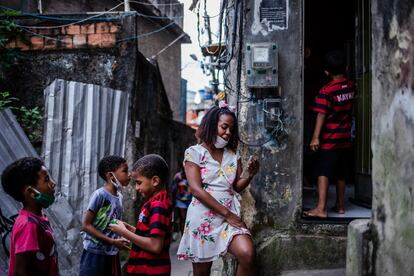 Rafaela Machado, de 29 años, habla con su hijo por videollamada en frente de su casa en la comunidad Cantagalo, en Río de Janeiro. Machado está separada y tiene cuatro hijos, y ha dependido del apoyo de las abuelas de sus niños, con quienes los tuvo que dejar durante los primeros cinco meses de la pandemia mientras que ella seguía trabajando fuera de casa, ayudando a su comunidad a enfrentar la crisis. Durante ese tiempo y hasta que pudieron volver a reunirse, Machado mantuvo contacto con sus hijos gracias a las frecuentes videollamadas.
