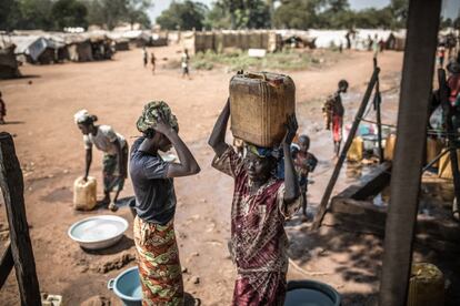 Un grupo de mujeres recogen agua en un punto de distribución instalado por Oxfam en el campo de desplazados de Batangafo (República Centroafricana).