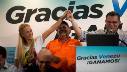 La esposa del Leopoldo López, Lilian Tintori, levanta la mano junto a Enrique Marquez.