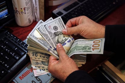 : A money changer counts U.S. dollar banknotes at a currency exchange office in Ankara, Turkey