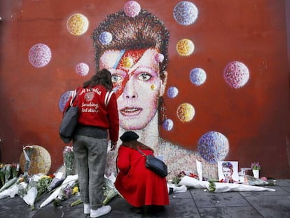 Mulheres deixam flores diante do mural de David Bowie em Brixton, no sul de Londres.