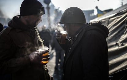Las últimas cifras oficiales, del Ministerio de Sanidad, señalan que desde el martes, cuando estalló el brote de violencia, han muerto en Kiev 77 personas, cifra que los opositores elevan a más de cien. En la imagen, unos manifestantes toman una bebida caliente, 21 de febrero de 2014.