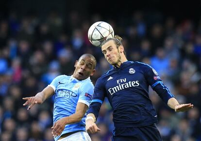 Gareth Bale (d) del Real Madrid golpea el balón de cabeza junto a Fernando del Manchester City.