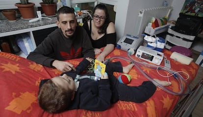 Aarón tendido en la cama en compañía de sus padres David y Verónica.