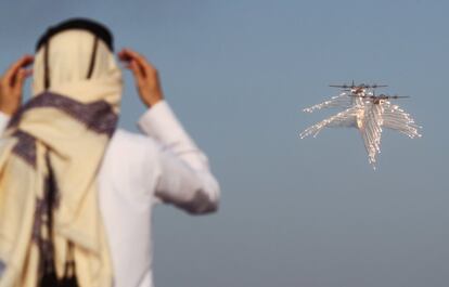 Un hombre observa a dos aviones que lanzan bengalas defensivas, durante una exhibición organizada para celebrar el Día Naciona de Qatar, en Doha.