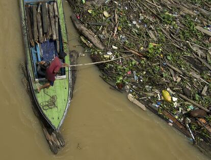 Un hombre recoge restos de basura en el desde el río Mahakam, en la ciudad de Samarinda (Indonesia).