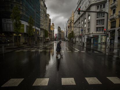 Una mujer cruza un paso de peatones en la Gran Vía de Madrid, el 23 de marzo de 2020, en pleno estado de alarma.