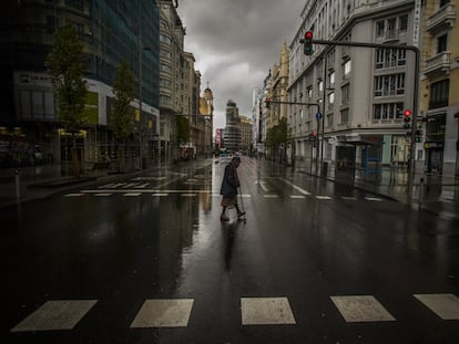 Una mujer cruza un paso de peatones en la Gran Vía de Madrid durante el confinamiento, el pasado marzo.