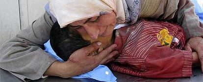 La madre de Dhiya Thamer llora sobre el cadáver de su hijo, de seis años, muerto en un fuego cruzado en Baquba.