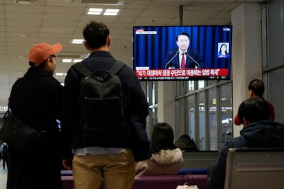 Varias personas siguen el mensaje televisado del presidente surcoreano, Yoon Suk-yeol.