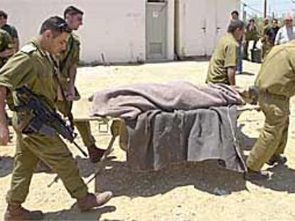 Soldados israelíes trasladan el cadáver del militante de Hamás Abdel Karim Maname, muerto ayer en la franja de Gaza.