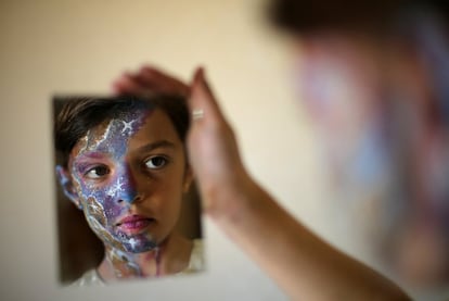 Una niña palestina se mira en un espejo después de que la maquillase la artista de efectos especiales, Alaa Abu Mustafa, en Gaza.