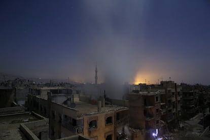 Una cortina de humo emana de un edificio de viviendas tras los bombardeos de las fuerzas gubernamentales siria sobre la zona controlada por los rebeldes en el barrio de Douma, al este de Damasco (Siria).