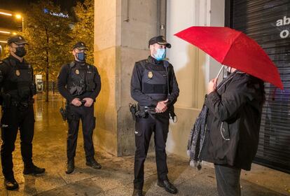 Unos policías informan a un ciudadano sobre la aplicación del toque de queda desde las 23.00 a las 06.00 horas