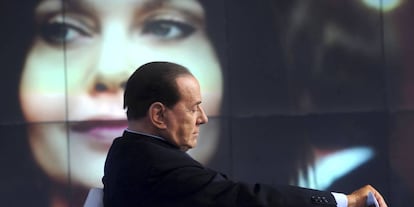 Silvio Berlusconi no primeiro plano, com sua ex-mulher Veronica Lario ao fundo da imagem