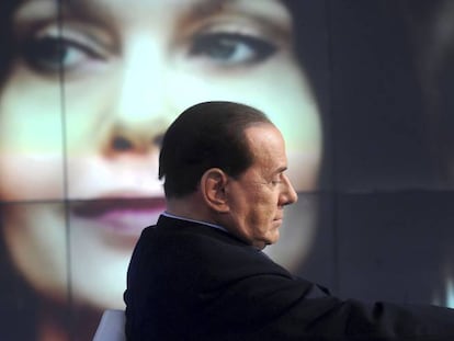 Silvio Berlusconi no primeiro plano, com sua ex-mulher Veronica Lario ao fundo da imagem