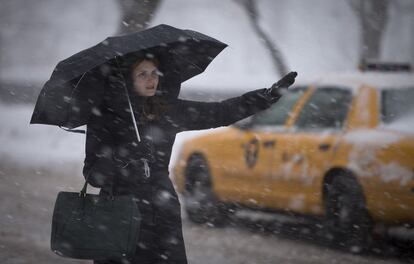 Una mujer pide un taxi en la Quinta Avenida en Central Park en Nueva York (EE UU). Los aeropuertos nacionales Dulles y Reagan de la capital se encuentran cerrados al igual que las escuelas en Filadelfia, Baltimore y Nueva York.