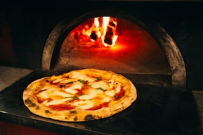 Una margarita sale del horno de la escuela de la Asociación de la Pizza Napolitana Verdadera.