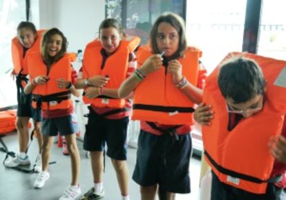 Los niños aprenden a emplear los chalecos en uno de los talleres que se imparten.