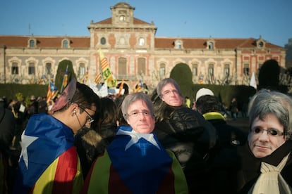 Manifestantes independentistas com máscaras de Puigdemont marcharam em apoio à posse do candidato.