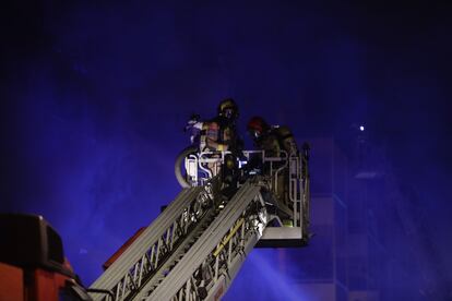 Los bomberos, durante las labores de extinción del incendio.