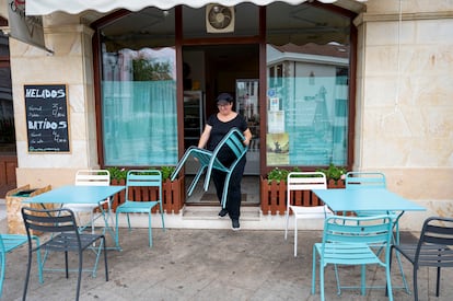 Una mujer prepara una terraza en Puente San Miguel (Cantabria).