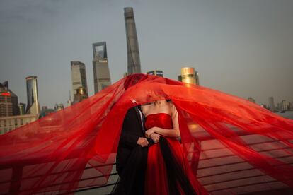 Una pareja posa para una sesión de fotos de preboda en la zona de Bund, frente a la Torre de Shanghái, el 16 de abril de 2018.