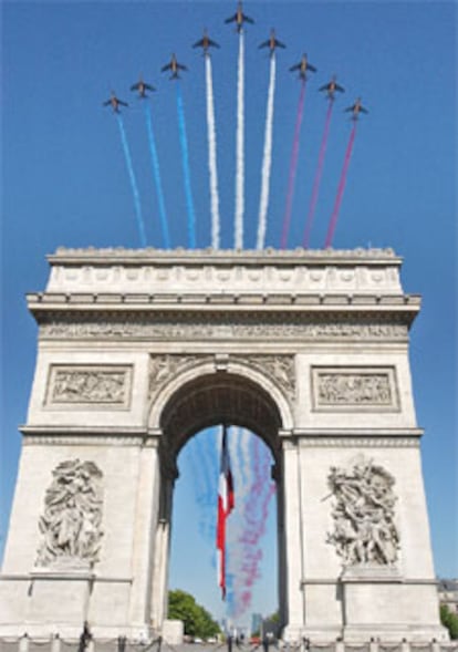 Una escuadrilla de aviones traza la bandera francesa sobre el Arco de Triunfo.