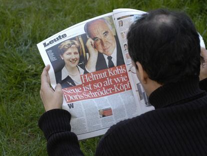 Un hombre lee la página del diario <i>Bild Zeitung</i> en la que Helmut Kohl confirma su noviazgo.