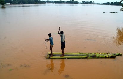 Niños indios pescan en las tierras inundadas en el pueblo de Sonaruguri en Nagaon, al Este de Guwahati. Al Menos 55 personas han muerto en las Inundaciones repentinas y deslizamientos de Tierra.