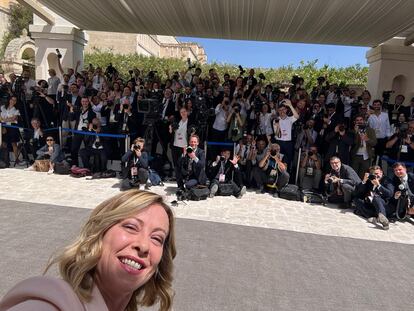 Giorgia Meloni se hace un selfi con los miembros de la prensa, justo antes de que llegara el presidente estadounidense Joe Biden, durante la cumbre del G-7, en una imagen distribuida por la oficina de prensa del palacio Chigi.