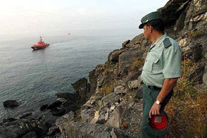 Un guardia civil observa desde la costa de Salobreña la zona donde fueron interceptados 14 inmigrantes.