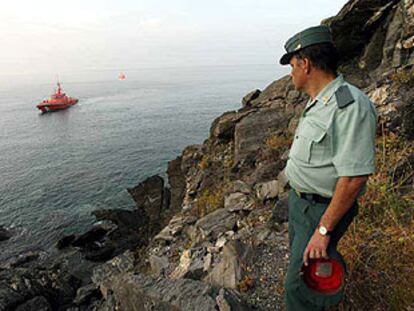 Un guardia civil observa desde la costa de Salobreña la zona donde fueron interceptados 14 inmigrantes.