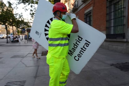 Un operario retira la señalética de Madrid Central, antes de que entre en vigor la nueva ordenanza de Movilidad Sostenible