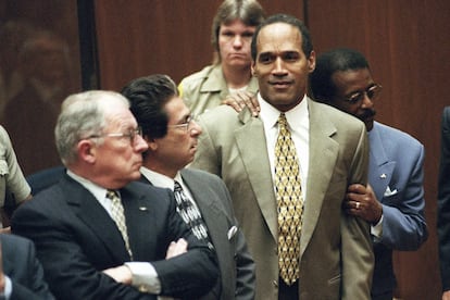 El abogado Johnnie Cochran Jr. sostiene a O.J. Simpson, el 3 de octubre de 1995, mientras se lee su veredicto en un tribunal de Los Ángeles. En la imagen también están los abogados defensores, F. Lee Bailey (izquierda) y Robert Kardashian (centro). 