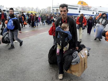 Um imigrante com um bebê chega na terça-feira a Atenas vindo das ilhas gregas.