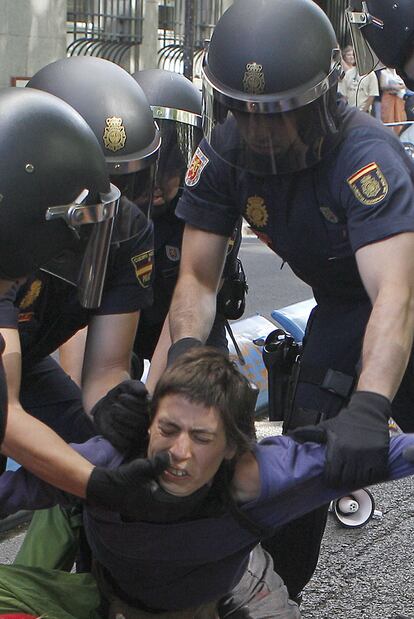 Varios policías levantan del suelo a una joven durante la carga policial que ha dispersado a los concentrados de la sentada que ha cortado tres de los cuatro carriles en el paseo del Prado. La Jefatura Superior de Policía ha asegurado que la operación se ha desarrollado "sin incidentes".