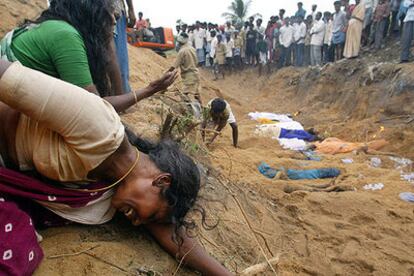 Familiares de víctimas del maremoto lloran la pérdida de sus seres queridos ante una fosa común en Cuddalore (India).