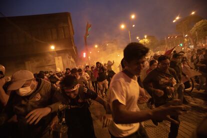 Manifestantes huyen de los gases lacrimógenos utilizados por la policía durante la protestas del domingo en Lima. 