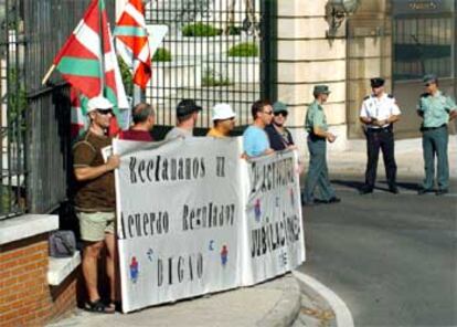 Miembros del sindicato ERNE junto a las pancartas colocadas en las puertas de La Moncloa.