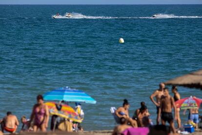 Numerosas personas disfrutan de un día de baño en la Playa de la Misericordia, desde donde el domingo partieron en una tabla de pádel-surf dos jóvenes de 29 y 34 años que continúan desaparecidos.