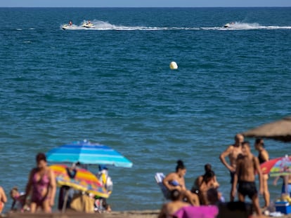 Numerosas personas disfrutan de un día de baño en la Playa de la Misericordia, desde donde el domingo partieron en una tabla de pádel-surf dos jóvenes de 29 y 34 años que continúan desaparecidos.