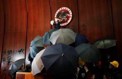 Un manifestante pinta el emblema de Hong Kong tras irrumpir en la sede del Parlamento, este lunes en Hong Kong (China)