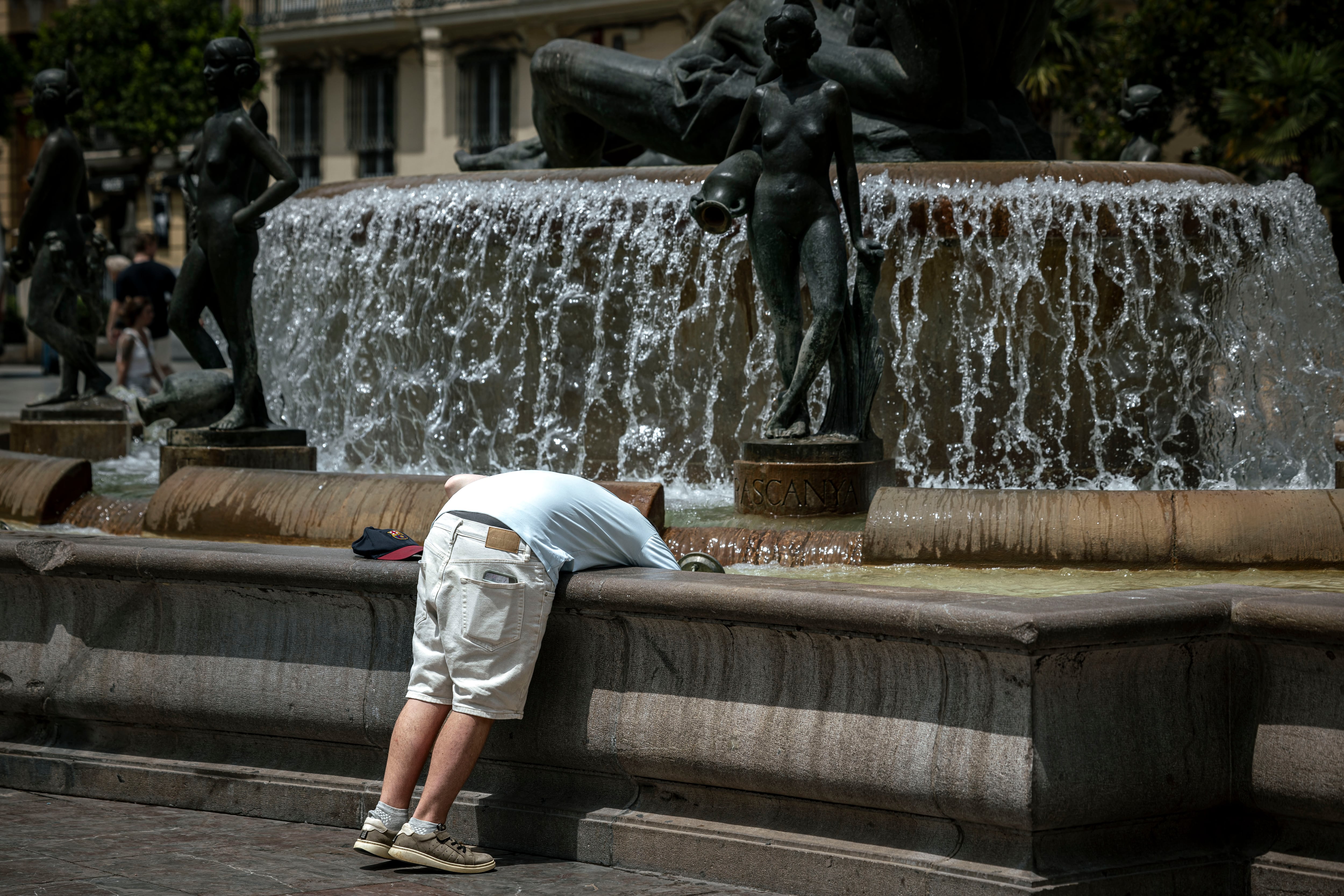 Varias personas se protegen del calor el pasado mes de julio en Valencia. 
