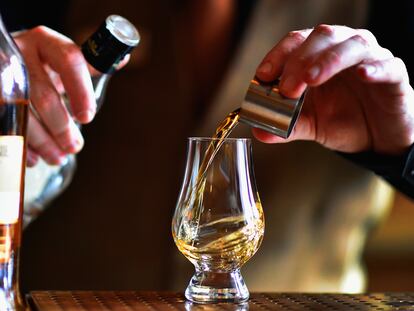 Un camarero sirve una copa de whisky en un 'pub' de Edimburgo, en Escocia (Reino Unido).